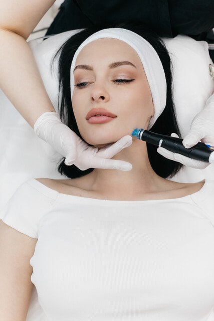 Esthetician performing a customized Hydroderm Facial on a woman at Embrace Eternal Beauty in Hot Springs, AR