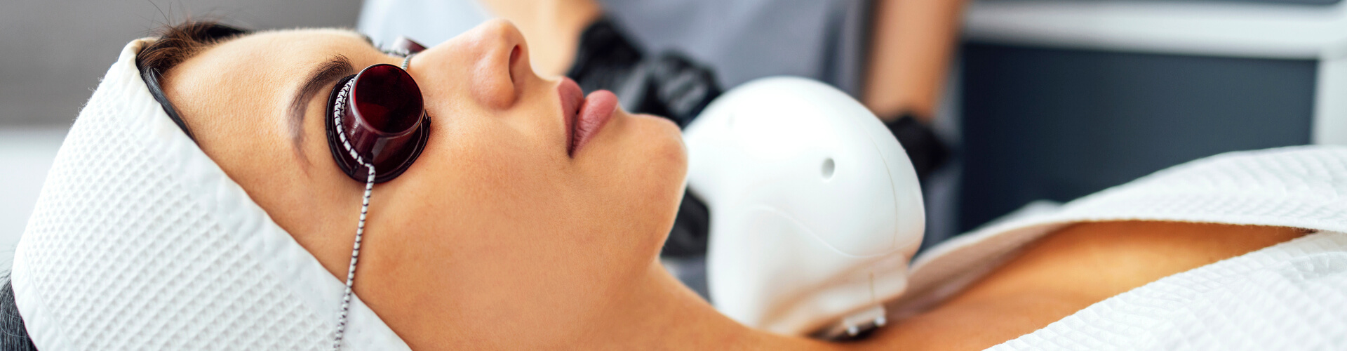 Close-up of woman receiving IPL in Hot Springs with protective eyewear during a facial rejuvenation treatment.