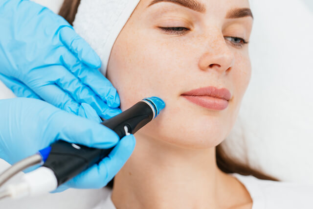 Close-up of a woman receiving a Hydroderm Facial exfoliation treatment at Embrace Eternal Beauty in Hot Springs