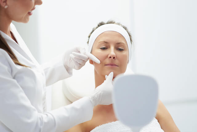 Medical provider evaluating a woman’s skin during a personalized consultation at Embrace Eternal Beauty in Hot Springs