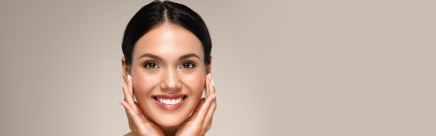 Close-up of a woman with smooth, glowing skin touching her face, luxury medspa aesthetic.